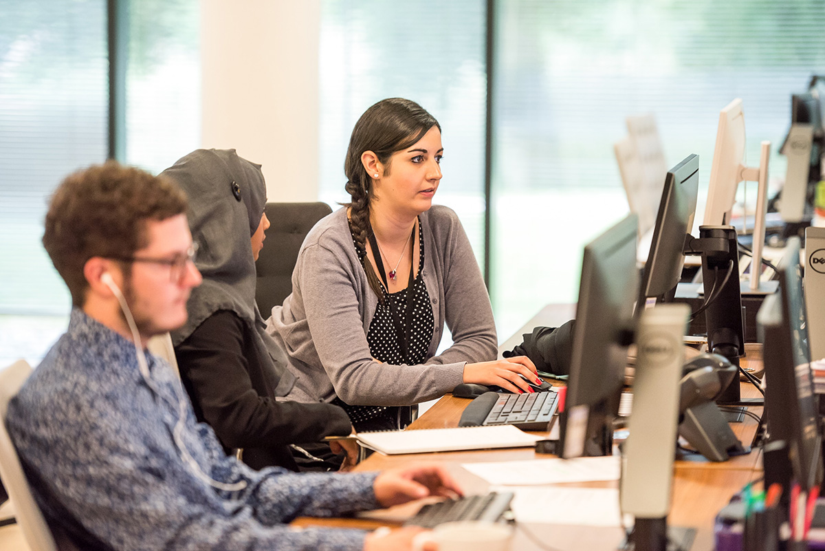 Carey Corporate account managers in an office working at their computers.